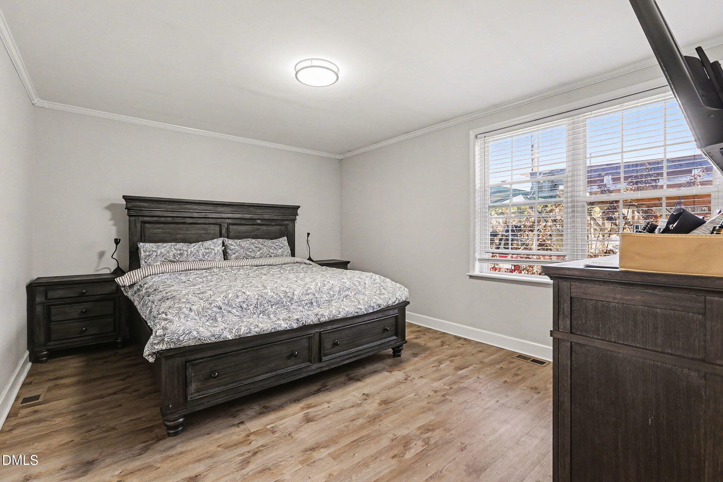 774 Abbott Road Henderson, NC 27537 - Photo 24 of 31 a bedroom with a bed window and wooden floor