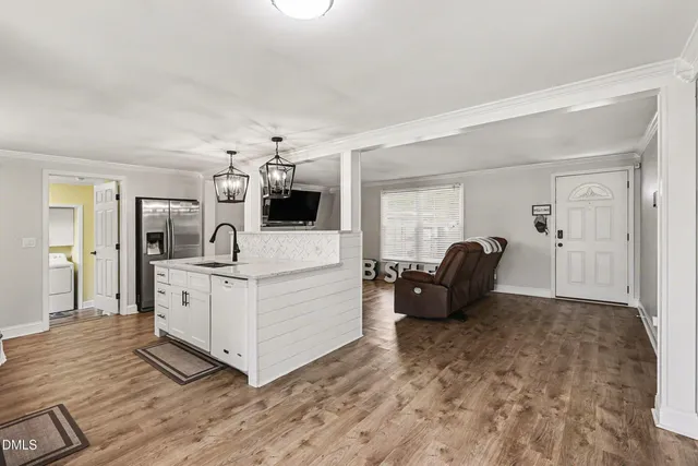 a kitchen with stainless steel appliances a sink a stove cabinets and a refrigerator