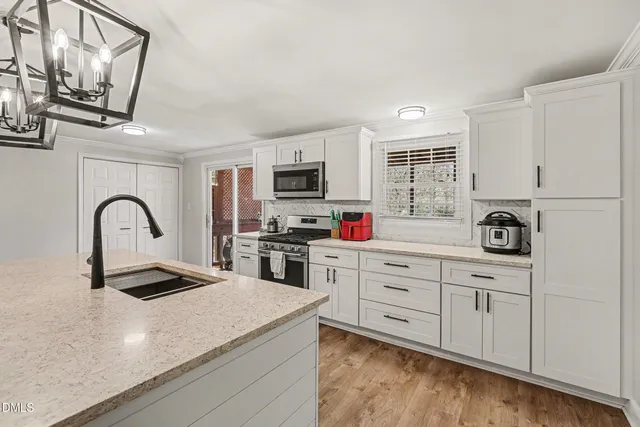 a kitchen with stainless steel appliances granite countertop a sink and a stove