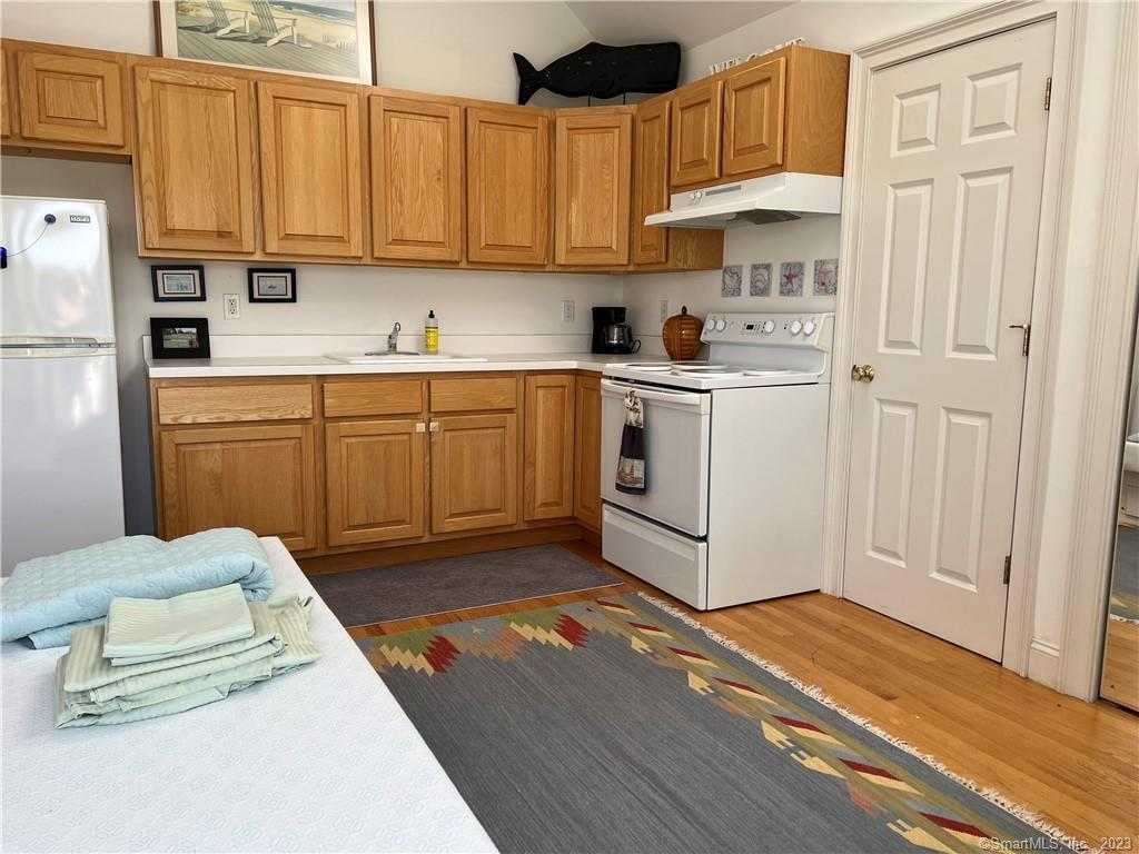 141 Middle Beach Road Madison, CT 06443 - Photo 3 of 8 a kitchen with stainless steel appliances granite countertop a stove a sink and a refrigerator