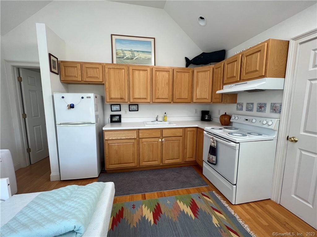 141 Middle Beach Road Madison, CT 06443 - Photo 6 of 8 a kitchen with a white cabinets and white appliances