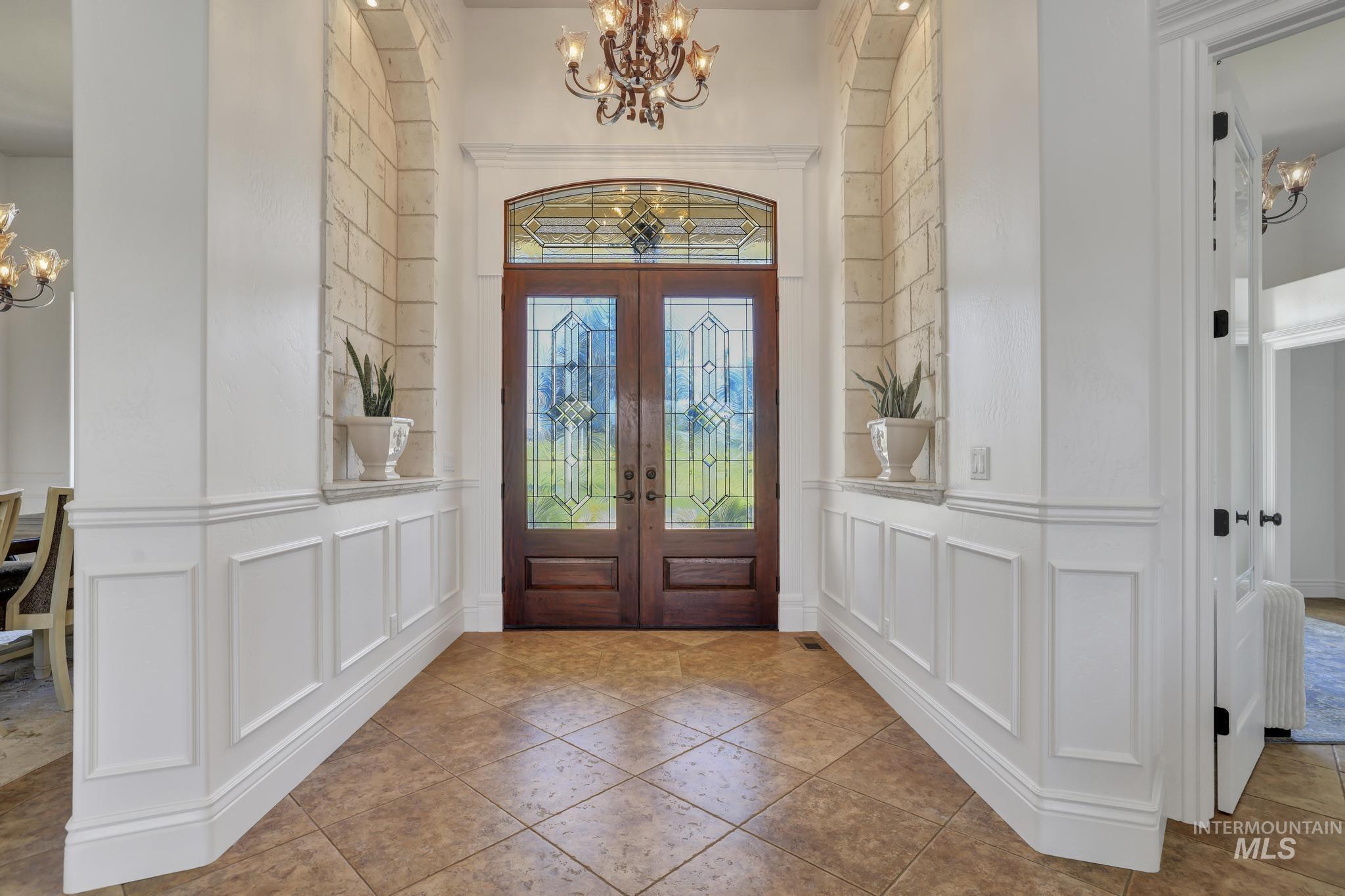 1301 Kanaka Rapids Road Buhl, ID 83316 - Photo 6 of 50 Entryway featuring double wood-finish doors with leaded glass, an arched transom window, and stone-accented wall niches
