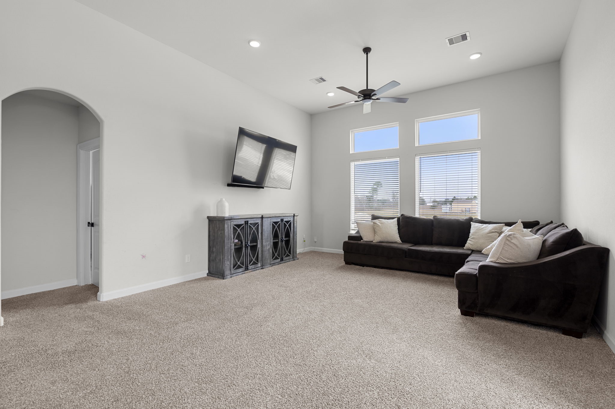 1294 County Road 5100 Cleveland, TX 77327 - Photo 14 of 27 A comfortable living room designed for relaxation and everyday enjoyment. Plush carpeting, recessed lighting, and large windows create a bright and welcoming atmosphere.