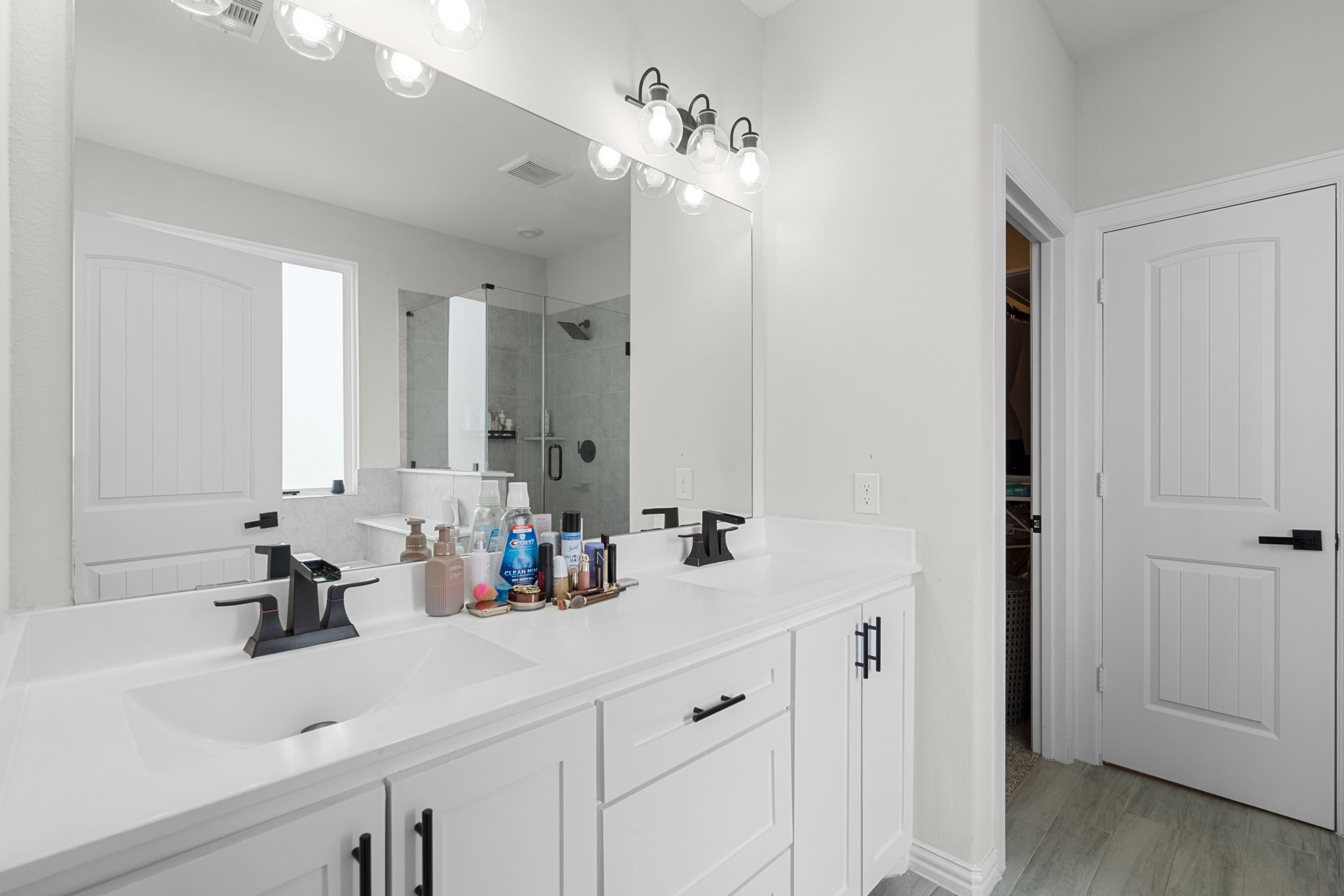 1294 County Road 5100 Cleveland, TX 77327 - Photo 18 of 27 Bright primary bathroom with dual-sink vanity, modern fixtures, and ample storage.
