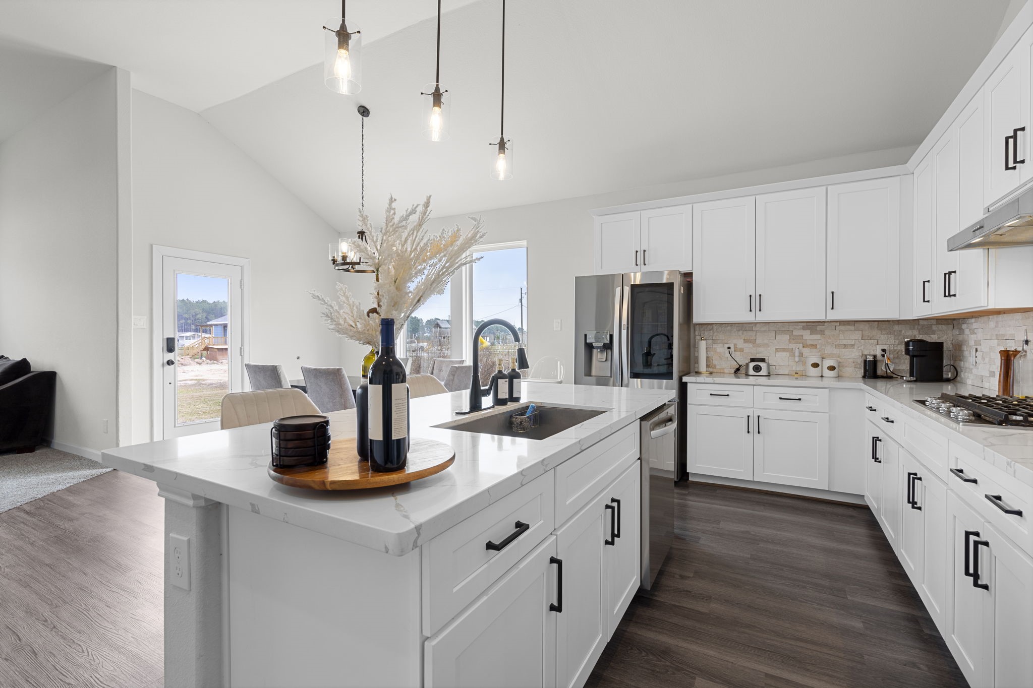 1294 County Road 5100 Cleveland, TX 77327 - Photo 7 of 27 An elegant view of the kitchen highlights pendant lighting, pristine cabinetry, and an inviting island perfect for casual dining or conversation.