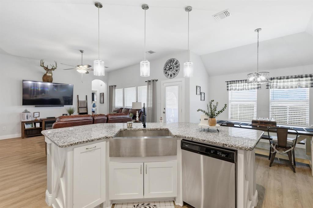 4101 Windmill Court Sanger, TX 76266 - Photo 12 of 36 a kitchen with stainless steel appliances granite countertop a sink a stove and a wooden floor