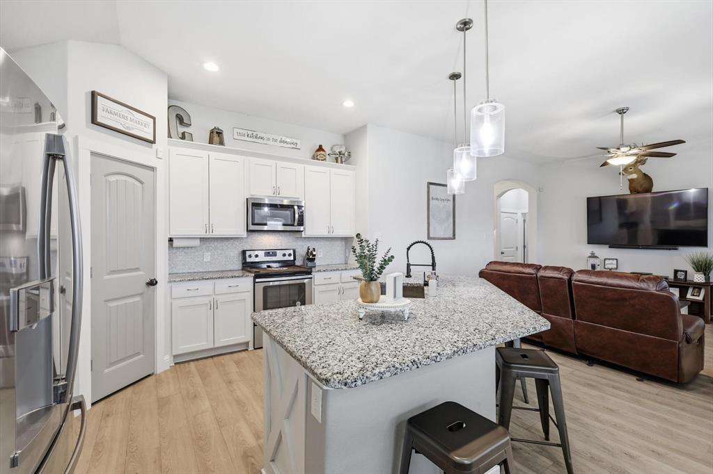 4101 Windmill Court Sanger, TX 76266 - Photo 14 of 36 a kitchen with stainless steel appliances granite countertop a stove refrigerator and a sink