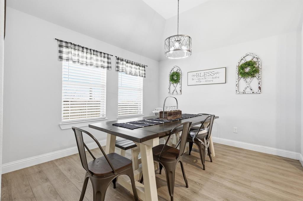 4101 Windmill Court Sanger, TX 76266 - Photo 17 of 36 a view of a dining room with furniture wooden floor and a chandelier