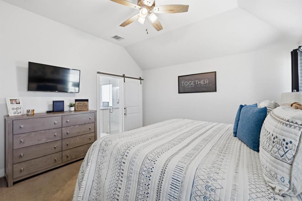 4101 Windmill Court Sanger, TX 76266 - Photo 19 of 36 a bedroom with a large bed and a flat screen tv