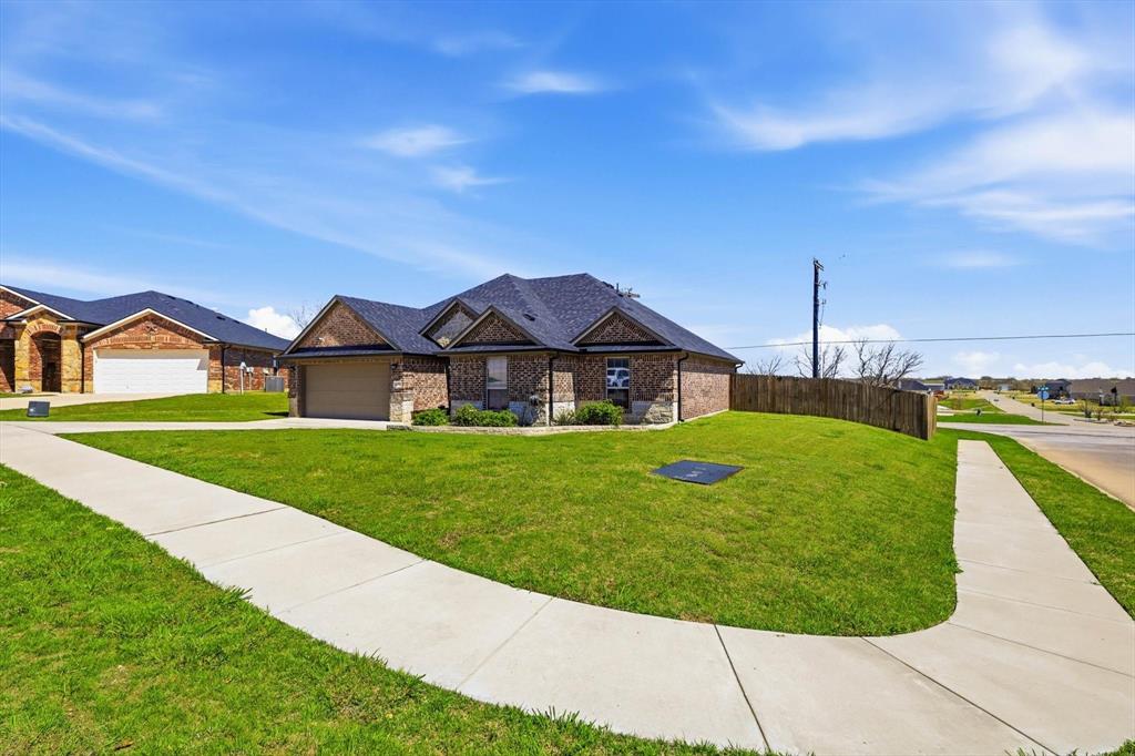 4101 Windmill Court Sanger, TX 76266 - Photo 2 of 36 a front view of a house with a yard