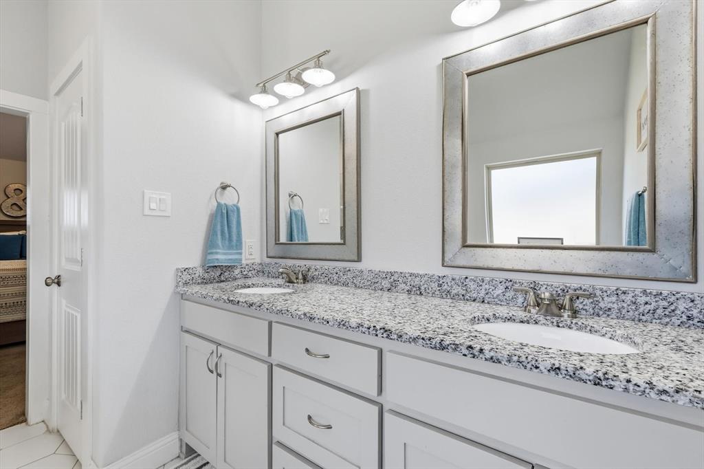 4101 Windmill Court Sanger, TX 76266 - Photo 23 of 36 a bathroom with a granite countertop sink and a mirror