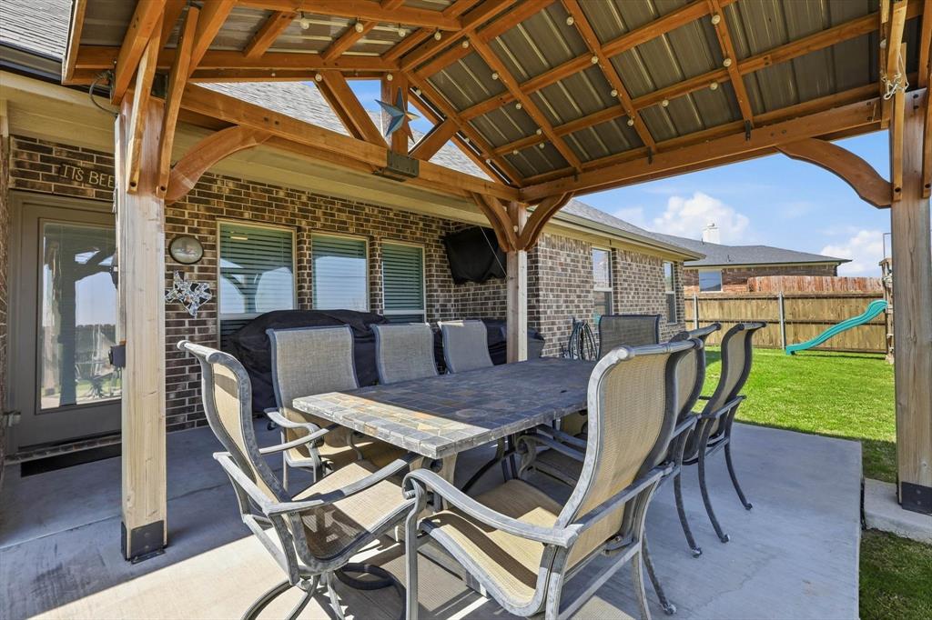 4101 Windmill Court Sanger, TX 76266 - Photo 30 of 36 a view of a patio with table and chairs with wooden floor and fence