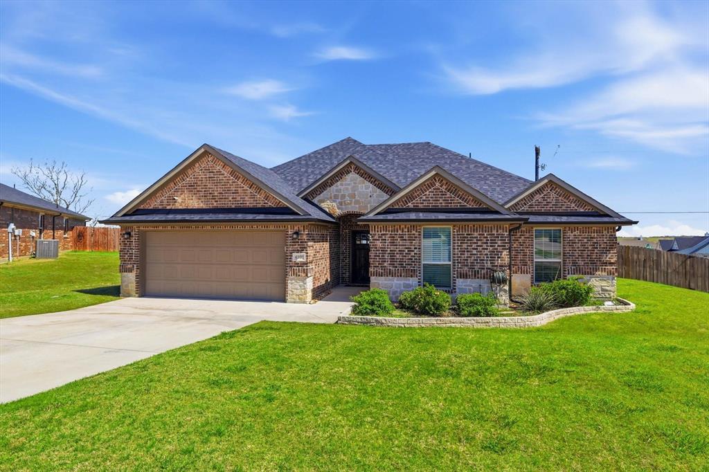 4101 Windmill Court Sanger, TX 76266 - Photo 3 of 36 a front view of a house with a yard and garage