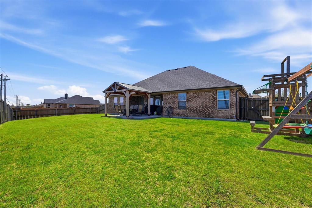 4101 Windmill Court Sanger, TX 76266 - Photo 34 of 36 a view of a house with a backyard