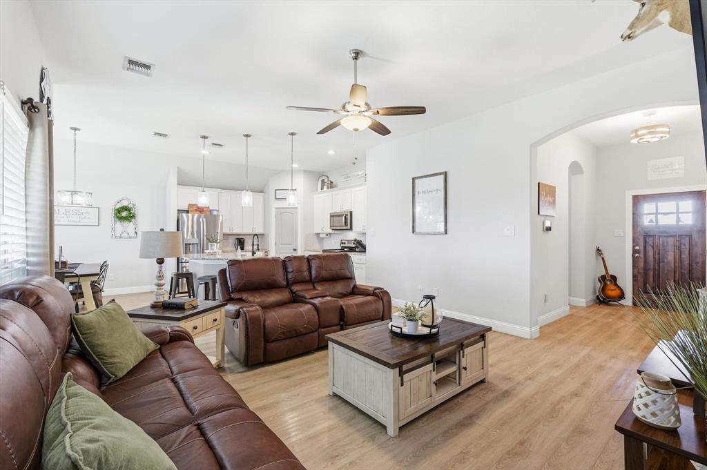 4101 Windmill Court Sanger, TX 76266 - Photo 9 of 36 a living room with furniture ceiling fan and a wooden floor