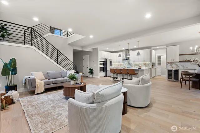 a living room with furniture kitchen view and a large window