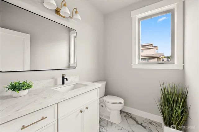 a bathroom with a toilet a sink and mirror