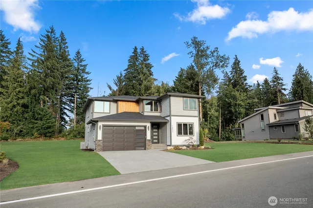 a front view of a house with a garden and trees