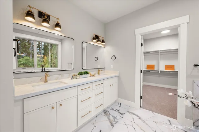 a bathroom with double vanity sinks and a mirror