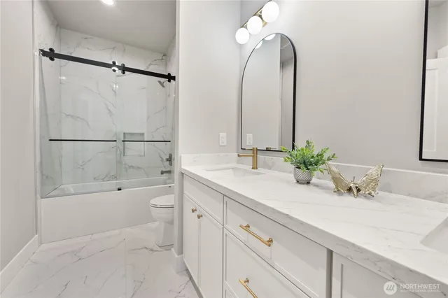 a bathroom with a double vanity sink toilet and shower