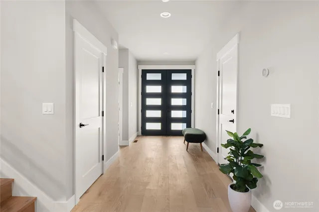 a view of a hallway with wooden floor and a potted plant