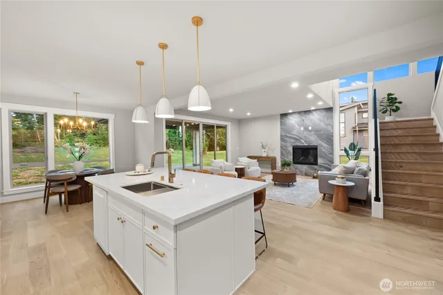 a open kitchen with stainless steel appliances granite countertop a stove and a fireplace