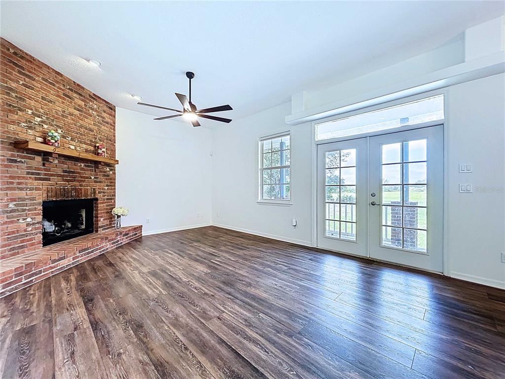 4103 North Rye Road Parrish, FL 34219 - Photo 12 of 40 wooden floor in an empty room with a fireplace and a window