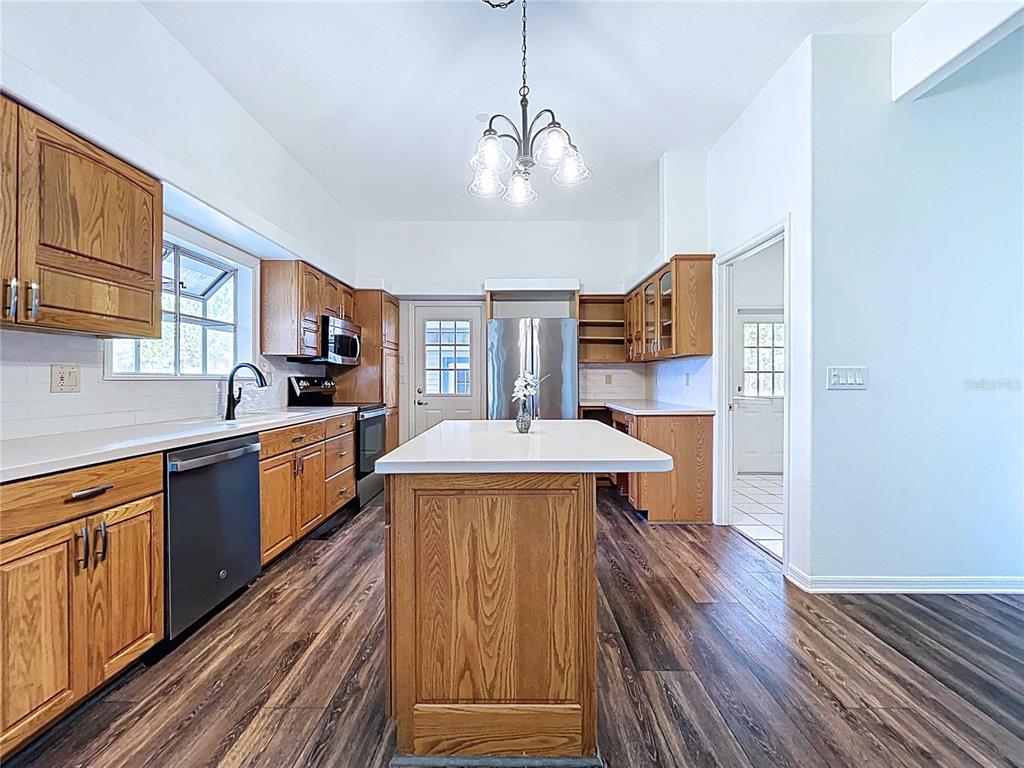 4103 North Rye Road Parrish, FL 34219 - Photo 14 of 40 a kitchen with kitchen island wooden floors appliances and cabinets