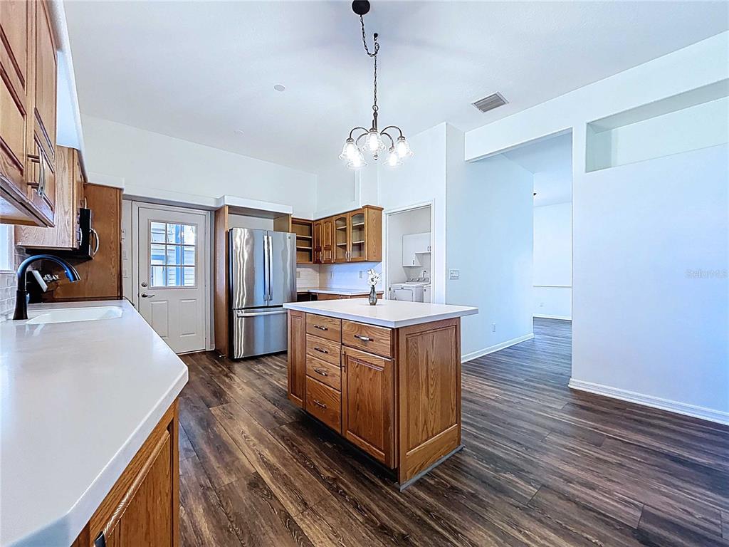 4103 North Rye Road Parrish, FL 34219 - Photo 15 of 40 a kitchen with stainless steel appliances granite countertop a sink a stove top oven a chimney wooden floor and cabinets