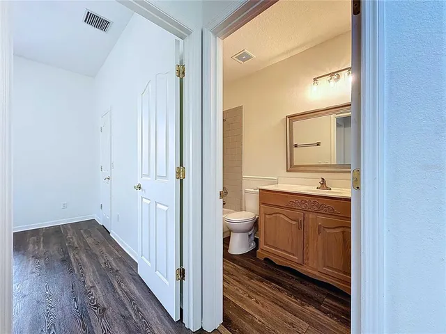 a bathroom with a granite countertop sink toilet and shower curtains