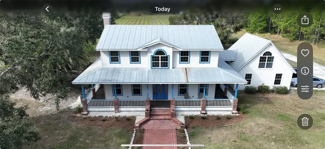 a aerial view of a house with swimming pool and wooden fence