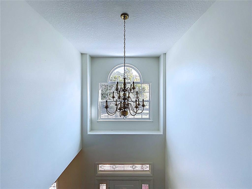 4103 North Rye Road Parrish, FL 34219 - Photo 22 of 40 a view of a hallway with windows and chandelier