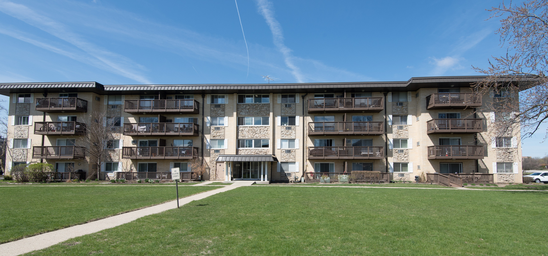 2218 South Goebbert Road, Unit 487 Arlington Heights, IL 60005 - Photo 20 of 23 a view of a big building with a big yard and large trees