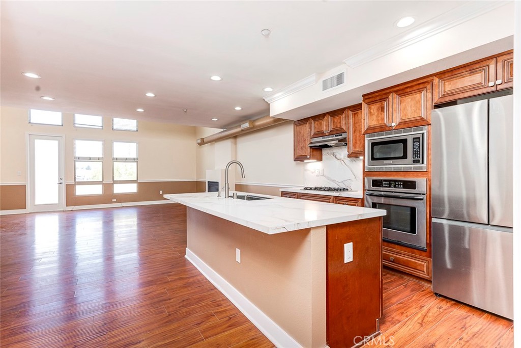 596 South Brea Boulevard Brea, CA 92821 - Photo 12 of 33 a kitchen with stainless steel appliances granite countertop a refrigerator a stove and a wooden floors