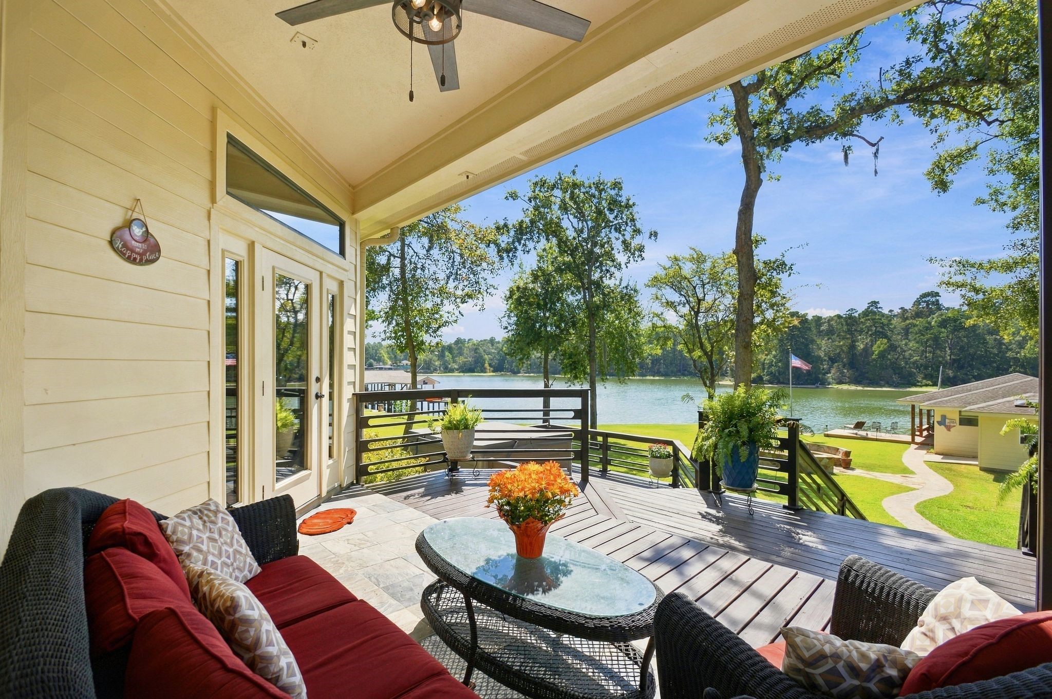 20341 Bay Hill Road Point Blank, TX 77364 - Photo 33 of 50 Enjoy breathtaking lake views from this charming covered patio, featuring cozy seating and a seamless transition to a spacious deck, perfect for relaxation and entertaining.