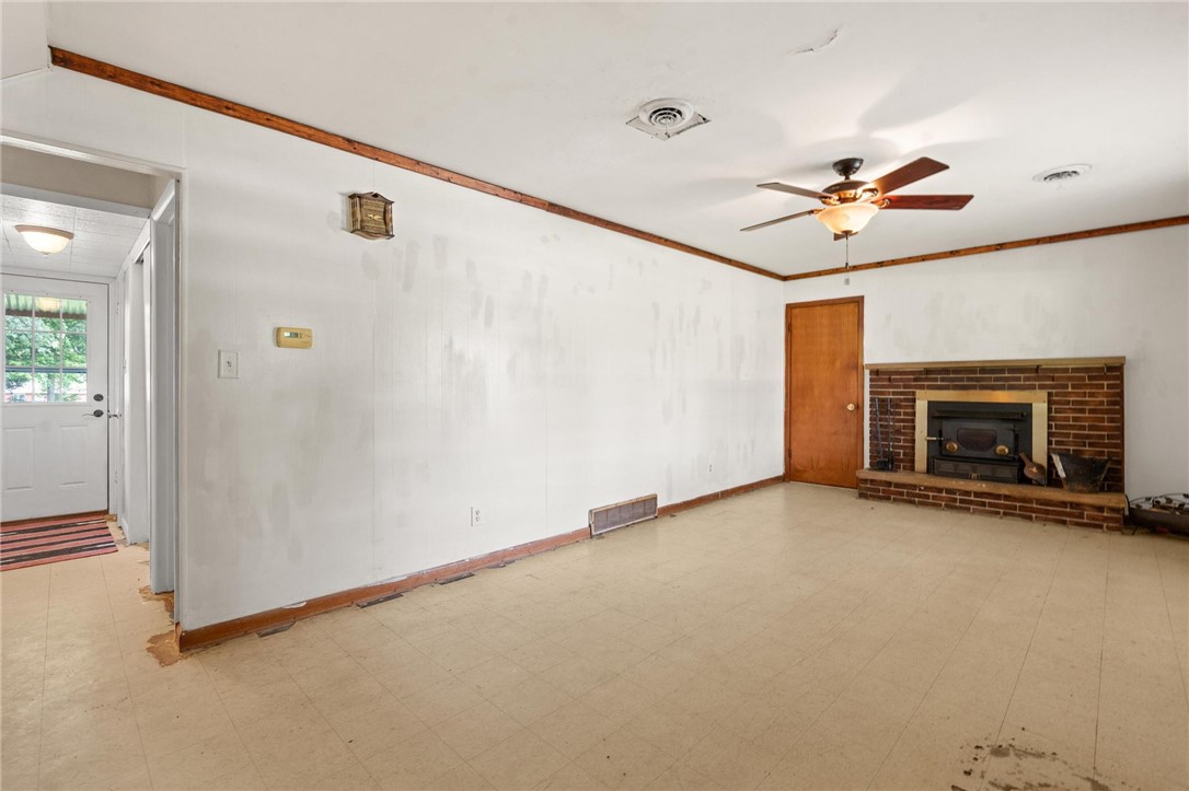 4150 Rose Marie Road Franklin, OH 45005 - Photo 12 of 36 A spacious living room features a classic brick fireplace and a warm wood-paneled ceiling, perfect for cozy gatherings.