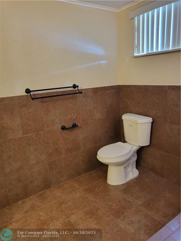 780 Northeast 199th Street, Unit E 101 Miami, FL 33179 - Photo 18 of 34 a white toilet sitting next to a bathroom sink