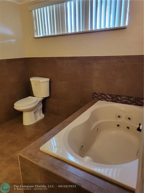 780 Northeast 199th Street, Unit E 101 Miami, FL 33179 - Photo 19 of 34 a bathroom with a bathtub and toilet