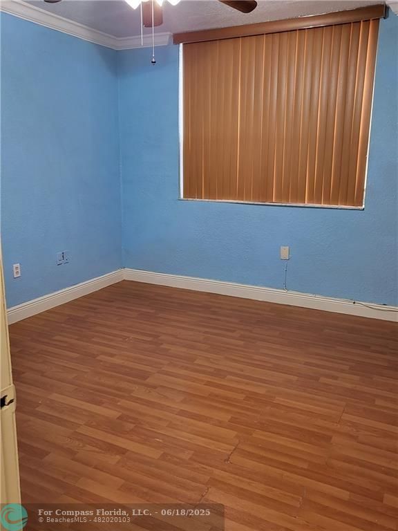 780 Northeast 199th Street, Unit E 101 Miami, FL 33179 - Photo 21 of 34 a view of an empty room with wooden floor