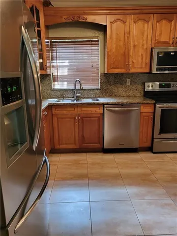 a kitchen with granite countertop a sink stove and cabinets