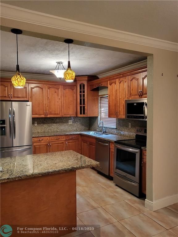 780 Northeast 199th Street, Unit E 101 Miami, FL 33179 - Photo 7 of 34 a kitchen with stainless steel appliances granite countertop a sink a stove and a wooden floors
