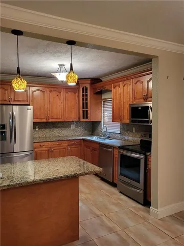 a kitchen with stainless steel appliances granite countertop a sink a stove and a wooden floor