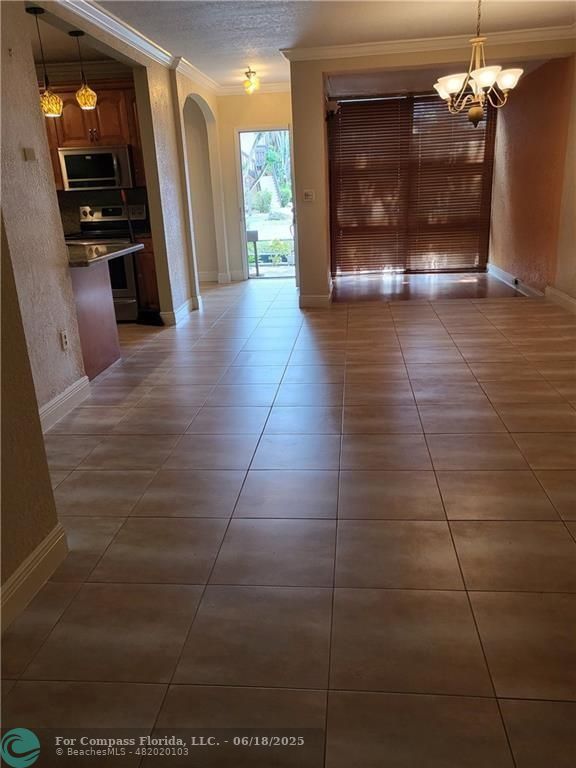 780 Northeast 199th Street, Unit E 101 Miami, FL 33179 - Photo 8 of 34 a view of a hallway with a dining table & chairs