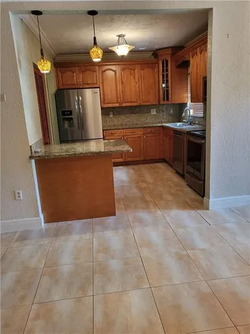 a kitchen with granite countertop a sink and a stove