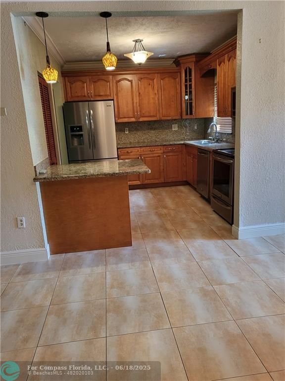 780 Northeast 199th Street, Unit E 101 Miami, FL 33179 - Photo 9 of 34 a kitchen with granite countertop a sink and a stove