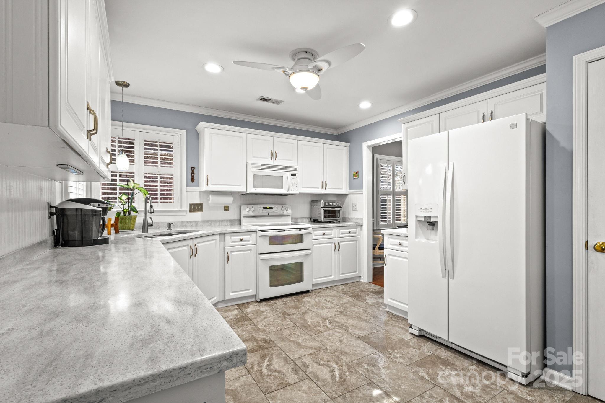 227 Point Wylie Lane Fort Mill, SC 29708 - Photo 11 of 36 a kitchen with a refrigerator a stove top oven a sink a dining table and chairs