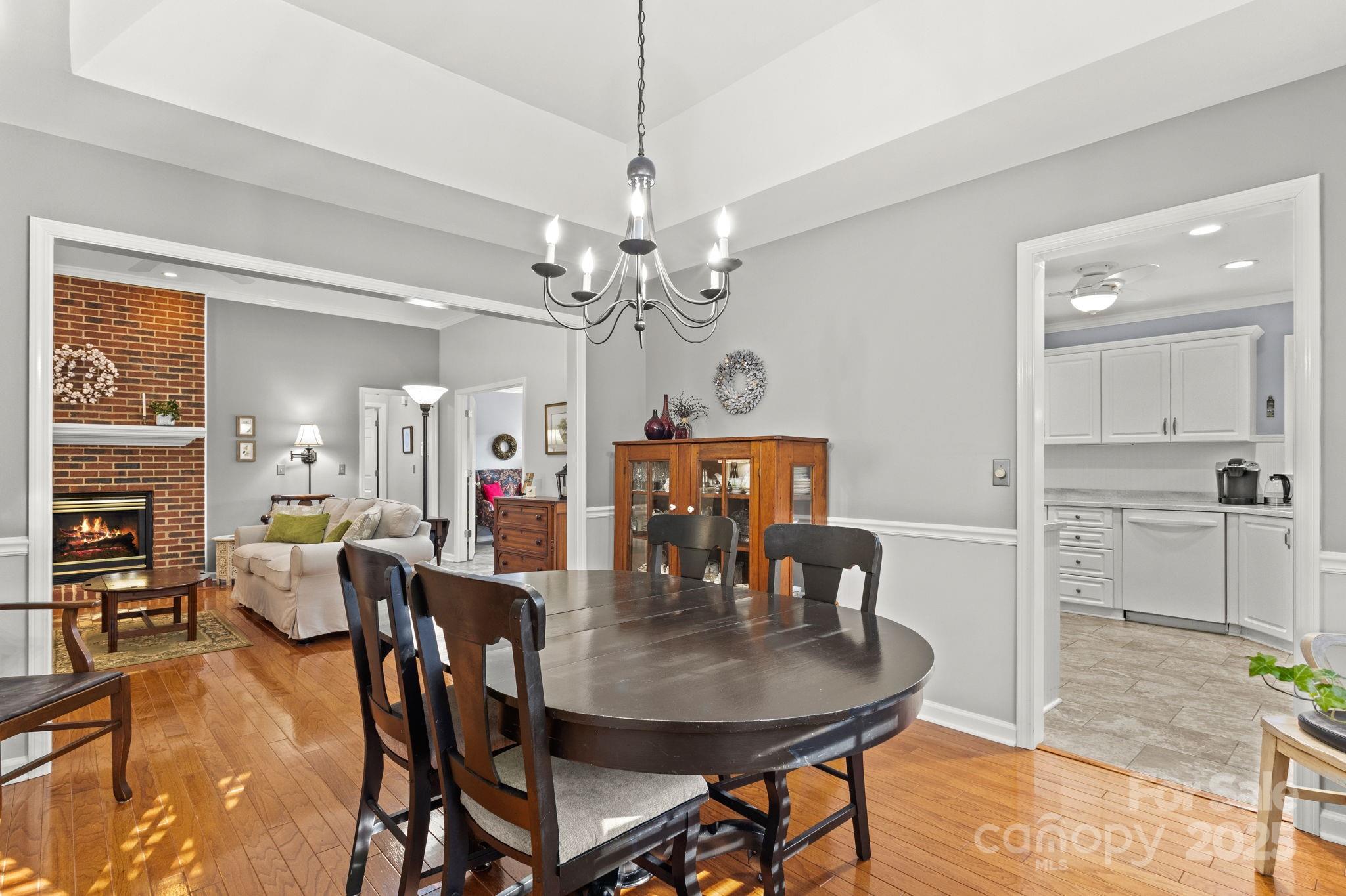 227 Point Wylie Lane Fort Mill, SC 29708 - Photo 8 of 36 a dining room with furniture a chandelier and wooden floor