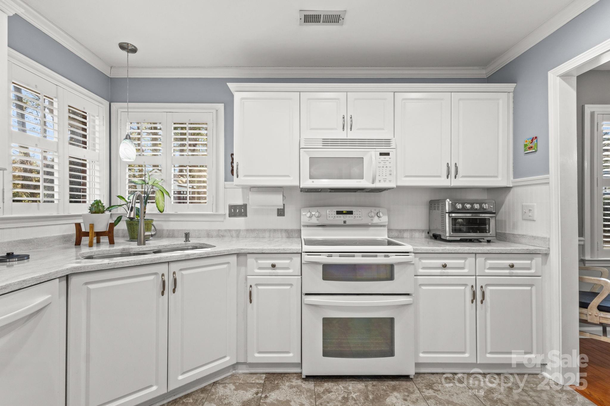227 Point Wylie Lane Fort Mill, SC 29708 - Photo 9 of 36 a kitchen with white cabinets and white appliances