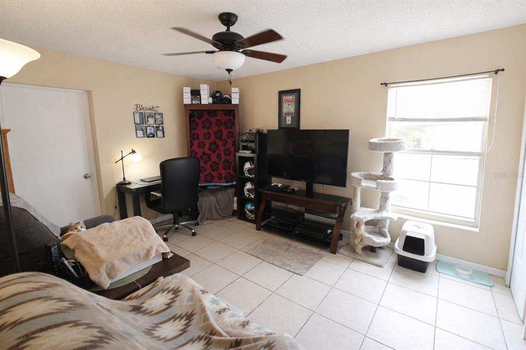 5046 Kenmore Street Spring Hill, FL 34608 - Photo 11 of 19 a bedroom with furniture and a flat screen tv