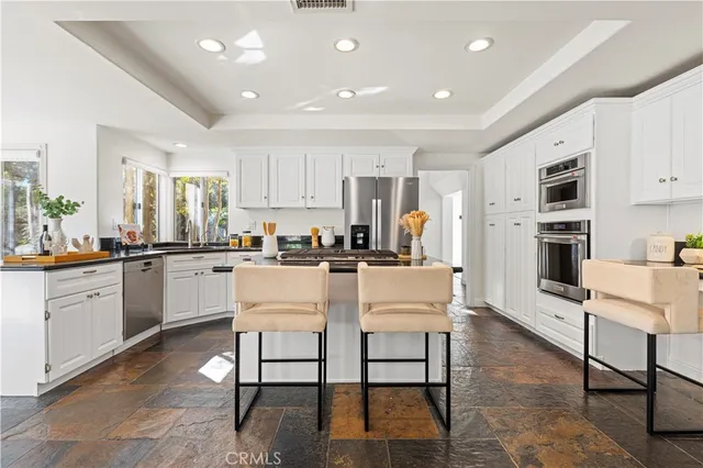 a kitchen with white cabinets and chairs